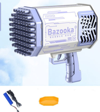 Pistolet à bulles blanc et violet avec ses ouvertures en façade, présenté avec une batterie, un câble de recharge et un plateau jaune .