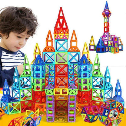 Enfant devant un grand château multicolore construit avec des pièces magnétiques carrées et triangulaires .